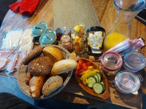 een tafel met een mand brood en een kom eten bij Jacuzzi huisje De Berenshoeve in Emmen
