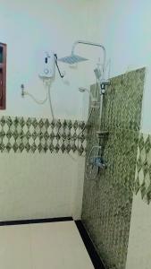 baño con ducha y bicicleta en la pared en Sunrise Relax Inn, en Beruwala