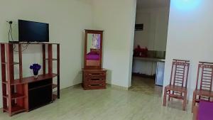 een woonkamer met een televisie en 2 stoelen bij Sunrise Relax Inn in Beruwala