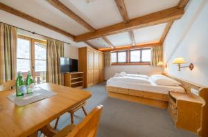 1 dormitorio con 1 cama, mesa y sillas en Gasthof Auwirt en Aurach bei Kitzbuhel