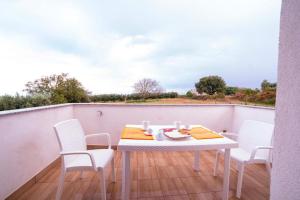 a white table and chairs on a balcony at Cascina Sàlaco in Zaccanopoli