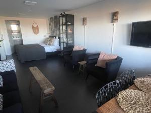 een woonkamer met een bed, een bank en stoelen bij B&B Zeespiegel in Zandvoort