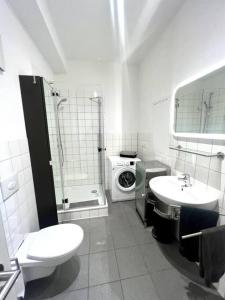 a bathroom with a toilet sink and a washing machine at Gemütliche Wohnung im Zentrum. in Bayreuth