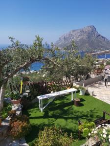 a white bench in a garden with a view of the ocean at Elsa's house in Kalymnos