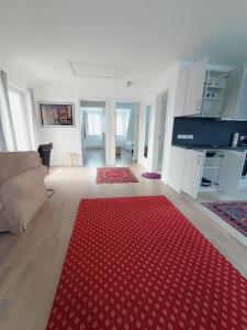 Peaceful Apartment- 3 Zi- Loggia & Garden in Blankenese- في هامبورغ: غرفة معيشة مع سجادة حمراء على الأرض
