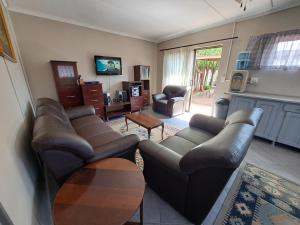 sala de estar con sofá y mesa en Feather Rest en Bloemfontein