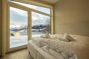 a bedroom with a large window with snow covered mountains at Microbolig på Rake in Stryn