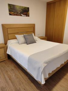 a bedroom with a large white bed with two pillows at Hotel Gastronómico Gandainas in Riós