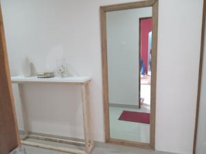 a mirror in a room with a shelf and a red rug at Chaya accommodation B&B and self catering in Mzuzu