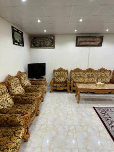 a living room with couches and a flat screen tv at Al Ramla, Na’eem Bin Masoud St#8, Villa#10 in Sharjah