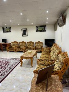 a living room with couches and a table and a tv at Al Ramla, Na’eem Bin Masoud St#8, Villa#10 in Sharjah