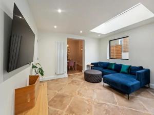 a living room with a blue couch and a table at Pass the Keys Modern and luxury London house in London