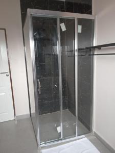 y baño con ducha y puertas de cristal. en Chaya accommodation B&B and self catering, en Mzuzu