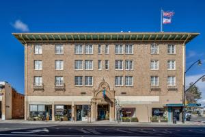 Hotel Petaluma, Tapestry Collection by Hilton في بيتالوما: مبنى من الطوب كبير عليه علم