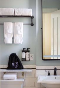 y baño con toallas, lavabo y espejo. en Hotel Petaluma, Tapestry Collection by Hilton, en Petaluma