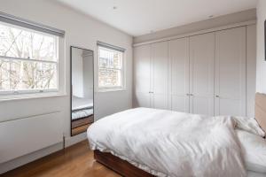 - une chambre blanche avec un lit et une fenêtre dans l'établissement Veeve - Good Vibrations, à Londres
