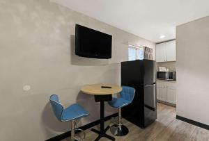 a kitchen with a table and two chairs and a tv on the wall at Rodeway Inn in Charlotte