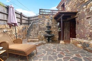 eine Außenterrasse mit einem Steingebäude mit einem Brunnen in der Unterkunft Bentayga Sensation in El Chorrillo
