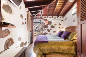 a bedroom with a bed in a stone wall at Bentayga Sensation in El Chorrillo