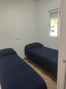 a bedroom with two beds and a window at Camping Barraquetes in Sueca