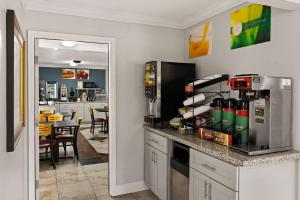 a kitchen with a counter with a refrigerator and a table at Quality Inn in Ocean Springs