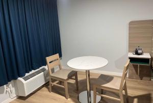 Habitación con mesa, 2 sillas y escritorio. en Travelodge by Wyndham Fairplex Pomona, en Pomona