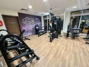 a gym with several treadmills and machines in a room at Ashri HH Brand New Creamy Rustic Studio in Dubai