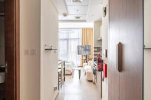 un couloir avec un salon et une salle à manger dans l'établissement Ashri HH Brand New Creamy Rustic Studio, à Dubaï