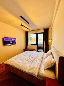 a bedroom with a bed and a tv on the wall at Ski Retreat in Poiana Brasov