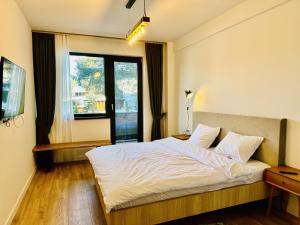 a bedroom with a bed and a large window at Ski Retreat in Poiana Brasov