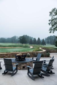 a patio with a table and chairs and a golf course at Waynesville Inn and Golf Club, Tapestry Collection by Hilton in Waynesville