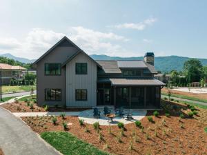 a house with a table and chairs in a yard at Waynesville Inn and Golf Club, Tapestry Collection by Hilton in Waynesville