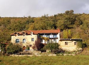 a large stone house in the middle of a field at Casa Apartamento Rural BlaBlao in Linares 