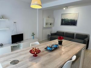 eine Küche und ein Wohnzimmer mit einem großen Holztisch in der Unterkunft Anastasia Apartment in Timişoara