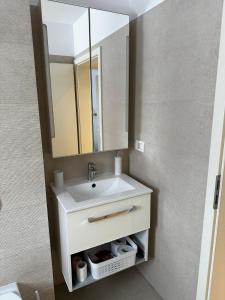 ein Badezimmer mit einem weißen Waschbecken und einem Spiegel in der Unterkunft Anastasia Apartment in Timişoara