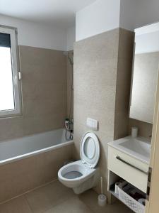 ein Badezimmer mit einem WC, einer Badewanne und einem Waschbecken in der Unterkunft Anastasia Apartment in Timişoara