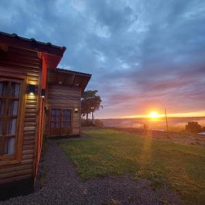 a cabin with the sunset in the background at Cabañas El Mirador in El Soberbio