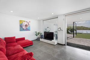 ein Wohnzimmer mit einem roten Sofa und einem TV in der Unterkunft Villa tulio homme 2 in Tijoco de Abajo