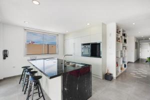 eine Küche mit weißen Wänden und einer Theke mit Hockern in der Unterkunft Villa tulio homme 2 in Tijoco de Abajo