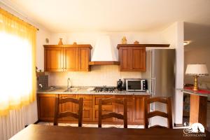 eine Küche mit Holzschränken und einem Kühlschrank aus Edelstahl in der Unterkunft Villa Cycas in Polpenazze del Garda