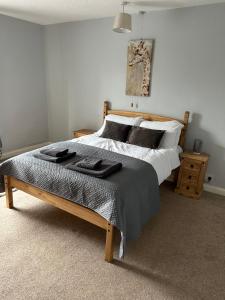 a bedroom with a bed with black towels on it at Cosy Cottage in Knottingly