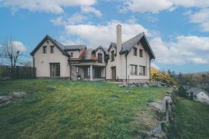a house on top of a grassy hill at Chalupa Lodge in Varvažov