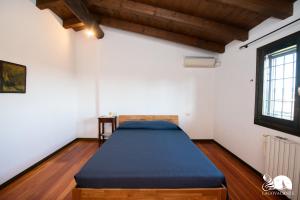 ein Schlafzimmer mit einem Bett in einem Zimmer mit einem Fenster in der Unterkunft Villa Cycas in Polpenazze del Garda