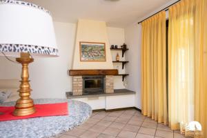 a living room with a fireplace and a lamp at Villa Cycas in Polpenazze del Garda