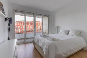 1 dormitorio con 1 cama blanca grande y ventana grande en Bright with terrace- 2Bd 2Bth- Salamanca en Madrid