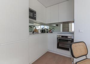 a kitchen with white cabinets and a chair in it at Bright with views -2Bd 1Bth- Bernabeu in Madrid