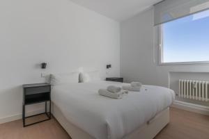 een slaapkamer met een wit bed en handdoeken bij Bright with views -2Bd 1Bth- Bernabeu in Madrid
