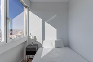 a white bedroom with a bed and a window at Bright with views -2Bd 1Bth- Bernabeu in Madrid