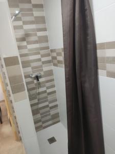 y baño con ducha con cortina negra. en Camping Barraquetes en Sueca