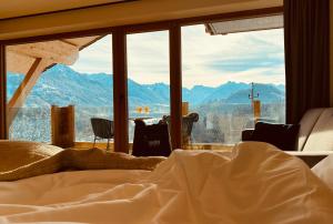 a bedroom with a bed and a view of mountains at Hotel Bergflair in Fischen